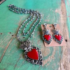 "Based on the Mexican tin heart wall decorations, these solid metal cast Sacred Heart pieces have a vintage silver finish with red resin heart filling.  Though they're solid, the earrings are not very heavy. Metal \"stud\" type attachments with stopper included to help secure your earrings better. Earrings measure about 2\" x 1.2\". Double Strand Necklaces are 20\" and 18\" long. Heart is 2.5\" x 1.5\" Items are sold separately." Vintage Metal Heart Earrings For Valentine's Day, Vintage Silver Heart Metal Earrings, Vintage Silver Metal Heart Earrings, Vintage Silver Heart Earrings In Metal, Antique Silver Heart Jewelry With Oxidized Finish, Vintage Silver Heart Earrings, Vintage Silver Heart Earrings For Valentine's Day, Silver Vintage Heart Earrings For Valentine's Day, Vintage Red Jewelry With Heart Beads