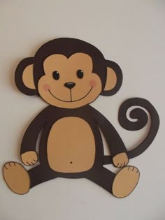 a wooden monkey cutout hanging on the wall