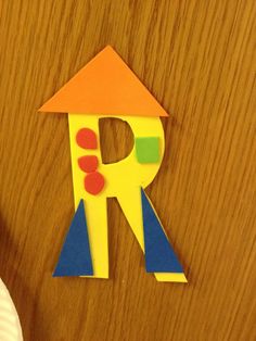 a piece of paper cut out to look like a rocket ship with the letter r on it