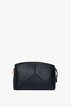 The latest addition to the house’s leather goods edit, this luxuriously textured clutch bag in refined Navy is a favourite of Victoria’s. Featuring a structured silhouette with an elegant curved top, it has several notable features, including a branded padlock serving as zipper and closure, a snap button at one side to hold the zip tail in place and leather panels stitched to form a V shape. A flat internal pocket ensures secure storage of smaller items. Victoria Beckham Exclusive Victoria Cross Timeless Business Clutch With Removable Pouch, Chic Business Clutch With Removable Pouch, Chic Evening Bag With Removable Pouch For Business, Chic Leather Pouch For Formal Occasions, Chic Formal Shoulder Pouch, Versatile Evening Shoulder Bag With Smooth Grain, Leather Evening Cosmetic Pouch, Elegant Pouch With Top Handle, Chic Travel Clutch With Smooth Grain