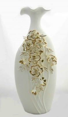 a white vase filled with lots of gold flowers