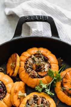 stuffed pumpkins with nuts and herbs in a cast iron skillet on a table