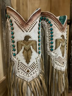 Irresistible, stunning, and flirty. This Corral Women's beige boot is a great choice for a fun night or an every day edgy style sure to catch everyones eye. This 14-inch shaft with its fun chain and leather fringe, turquoise studs, tan embroidery, and crystals will have you turning everyones head to admire them.You can wear this style all day without worrying about getting tired. It features; sturdy pull-on straps and an elegant snip toe. The smooth inside leather lining, cushioned leather insole, leather outer sole with a rubber insert and rubber heel cap, and 2 1/2 -inch stacked heel, scream comfort. Lightly cushioned footbed Fun chain and leather fringe Crystal Accents 14" shaft Snip toe 15" calf circumference 2.75" heel Vamp: Cowhide Cowboy Heel Leather Sole Cowgirl Boot Outfits, Western Concert Outfit, Punchy Western Outfits, Turquoise Cowgirl, Snip Toe Cowgirl Boots, Western Boots For Women, Bling Boots, Fringe Cowboy Boots, Turquoise Crystals