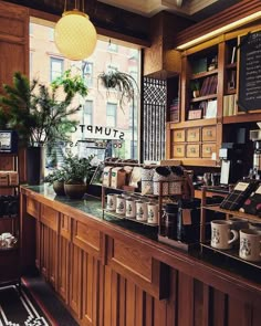 a coffee shop filled with lots of different types of items and plants on the counter