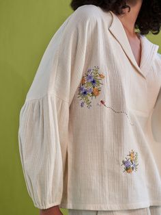 Relaxed fit, long puff sleeve, v-neck shirt crafted in double gauze organic cotton fabric that's embroidered with botanic-inspired motifs. This classic, staple shirt is so versatile and can be endlessly mixed-and-matched to create a fresh outfit each time you put it on. Techniques Used: Hand Embroidery. #cuteeverydayoutfits #prettyoutfits #falloutfitswomen #shirtdesign #topsforwomen Fall Cotton Blouse With Embroidered Cuffs, Cotton Blouse With Embroidered Cuffs, Casual Cotton Blouse With Embroidered Cuffs, Spring V-neck Blouse With Chikankari Embroidery, Cotton Shirt With Gathered Long Sleeves, Spring Linen Shirt With Floral Embroidery, Fall Linen Tops With Floral Embroidery, Long Sleeve Cotton Blouse With Embroidered Cuffs, Linen Tops With Floral Embroidery For Fall