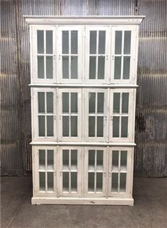 an old white cabinet with glass doors