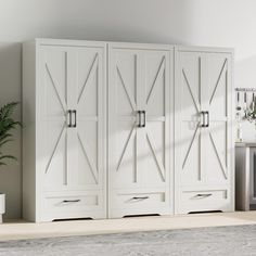 a large white cabinet sitting next to a potted plant