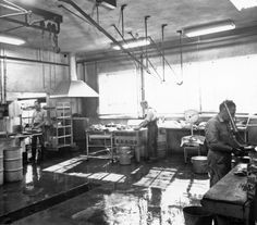 an old black and white photo of workers in a kitchen