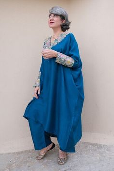 Blue kaftan with resham, zardozi applique embroidered V neck and sleeve cuffs. Paired with printed straight fit pant.
Components: 2
Pattern: Applique Embroidered
Type Of Work: Resham and Zardozi Work
Neckline: V Neck
Sleeve Type: Batwing Sleeves
Fabric: Pure Silk
Color: Blue
Other Details: 
Cut work hem details
Asymmetric hem on kaftan
Note: The outfit worn by the other model on the left is not for sale
Occasion: Mehendi and Haldi,Sangeet - Aza Fashions Bollywood Style Blue Palazzo Set With Embroidered Border, Blue Bollywood Palazzo Set With Embroidered Border, Unstitched Blue Kaftan For Eid, Anarkali Kaftan With Embroidered Border For Eid, Designer Blue Kaftan With Chikankari Embroidery, Designer Long Sleeve Blue Kaftan, Festive Blue Straight Kurta Kaftan, Blue Festive Kaftan Straight Kurta, Blue Anarkali Kaftan With Traditional Drape