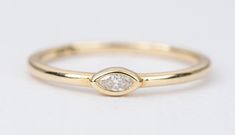 ♥ Marquise east/west set diamond bezel 14k yellow gold stacking ring ♥ The overall setting measures 5.4mm in width, 3.1mm in length, and sits 2.6mm tall from the finger ♥ Check here for our custom wedding band options: https://bit.ly/2QEpLqi ♥ Ring size: US 6, 7 & 8 available in stock (Free resizing) ♥ Ring width: 1.72mm ♥ Material: 14K yellow gold ♥ Gemstone: Center diamond is 0.06ct ♥ Free shipping in the US. ♥ This item is in stock and ready to ship right away! Yellow Gold Stacking Rings, Gold Stacking Ring, Marquise Diamond Ring, Custom Wedding Band, Bezel Set Ring, Zierlicher Ring, Engagement Rings Marquise, Simple Ring, Gold Ring Stack