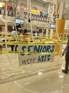 a man standing in front of a sign that says seniors were here taped to it