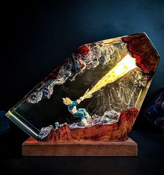 a glass sculpture with a light coming out of it's center and on top of a wooden base