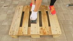 a woman standing on top of a wooden pallet with her feet in the air