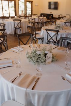 the tables are set with white linens and silverware