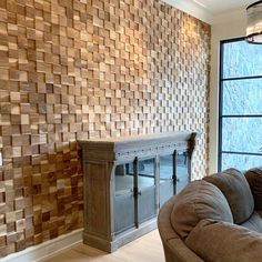 a living room filled with furniture next to a tall glass window covered in wood planks