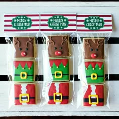 four decorated cookies in the shape of santa's helper and reindeer with christmas hats on them