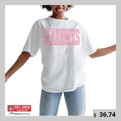 a woman wearing a white t - shirt with the words seahawks on it