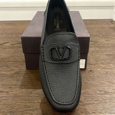 Valentino Garavani Driving Shoes In Grained Calf Leather Flat Driving Heel Round Toe Black Tone Signature V-Logo Ornament Leather Lining Branded Valentino Rubber Driving Sole Slip-On Style Made In Italy Brand New In Box Box Has Some Marks On Them , See Photos For Details Size 45 All Sales Are Final Luxury Formal Loafers With Textured Sole, Luxury Leather Sole Moccasins For Business, Luxury Round Toe Moccasins For Business, Luxury Business Moccasins With Leather Sole, Luxury Business Moccasins With Moc Toe, Business Leather Loafers With Textured Detail, Designer Business Moccasins With Textured Sole, Luxury Leather Shoes With Textured Sole For Business Casual, Luxury Business Moccasins With Textured Sole