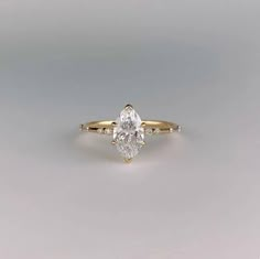 a yellow gold engagement ring with a pear shaped diamond