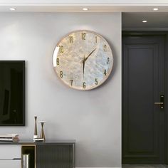 a living room with a large clock on the wall and a television in the corner