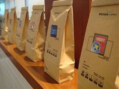 there are many bags lined up on the counter in front of the coffee bag holders