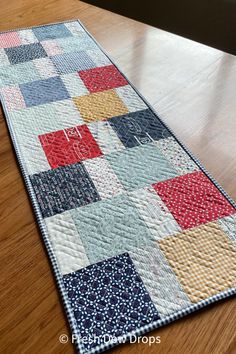 a patchwork table runner on a wooden floor