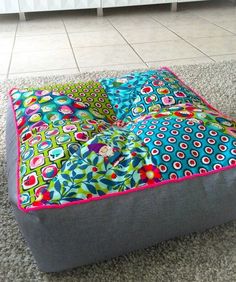 a colorful square shaped ottoman on the floor