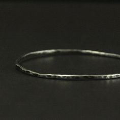 Add some rustic charm to your outfit or stack it with other bangles to add a little texture! This bangle is handmade just for you to the size of your choosing. It will be hand formed from 2mm diameter solid Sterling Silver round stock and hammered for a unique texture. Your bangle will then be oxidized and given a soft brushed finish to truly show off surface. This listing is for the Hammered Bangle ONLY. Please visit our shop for the bangles in the other photos. Blazer Arts is a family-owned an Hammered Sterling Silver Bracelets, Sterling Silver Hammered Bracelets, Hammered Sterling Silver Bracelet, Hand Forged Sterling Silver Bracelet As Gift, Minimalist Hand Forged Sterling Silver Bracelet As Gift, Hammered Silver Metal Bracelets, Hand Forged Silver Bracelets, Silver Hammered Metal Bracelets, Hand Forged Sterling Silver Bracelets