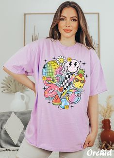 Get ready to rock that casual chic look with our Funny Smiley Face T-shirt ❤️ Get retro with this smiley Graphic Tee! Featuring smiley faces and a nostalgic vibe, this design is perfect for all the cool beach bums out there. Show off your retro style and spread some positive vibes with this fun and funky t-shirt. ❤️ Size up, babe! Go 1-2 sizes bigger for that oversized stunner. Elevate your style, own the spotlight, and unleash your fashion power. It's time to rock the room with your effortlessl Retro T-shirt For Vacation, Funky Tshirts Designs Graphic Tees, Casual Purple T-shirt With Cartoon Print, Oversized Purple T-shirt For Summer, Trendy Relaxed Fit T-shirt With Cartoon Print, Playful Graphic Print T-shirt For Vacation, Oversized Cartoon Print T-shirt For Summer, Trendy Shirt For Day Out, Casual Tops With Cartoon Print And Relaxed Fit