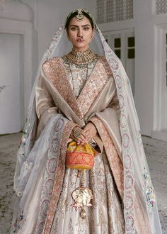 a woman in a bridal gown and veil poses for the camera with her hand on her hip