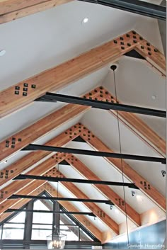 the inside of a building with wooden beams and lights hanging from it's ceiling