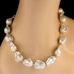 Introducing an exquisite 19-inch Giant White Baroque Pearl Necklace that exudes timeless elegance and charm. Each pearl, measuring an impressive 16-19mm, showcases a captivating iridescent sheen and unique organic shape, making every single one a true work of art. The baroque pearls are complemented by sparkling crystal accents, adding a touch of modern sophistication to this classic design. This fabulous necklace is destined to become your go-to accessory, whether you're dressing up for a speci Pearl White High Luster Necklace For Anniversary, White Baroque Pearl Necklace, Iridescent Pearl, Baroque Pearl Necklace, Sparkling Crystal, Baroque Pearls, Organic Shapes, Lobster Claw, Classic Design