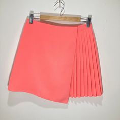 "Unusual mini skirt by Topshop in a vibrant peach crepe fabric. The skirt is a full wrap skirt with an asymmetric design, giving the impression of skirts, one plain and one pleated, overlayed . Fully lined. Button fastening.  In good condition with no signs of wear. Measurements Waist: 26\" Length 15\"" Peach Crepes, Pink Wrap, Wrap Mini Skirt, Asymmetrical Design, Crepe Fabric, Peach Pink, Wrap Skirt, Modern Vintage, Cheer Skirts