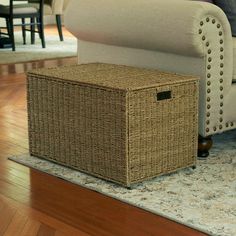 a wicker storage box sitting on the floor next to a couch in a living room