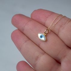 Εxtra tiny 14k solid gold evil eye pendant.  The pendant measures 11mm / 0.4 inches The evil eye pendant is available in 14k yellow gold with a white evil eye.  The  eye is made of mother of pearl (mop). The backside is closed, smooth 14k solid gold. Available with a solid 14k gold chain or as pendant only. Chains are available in 3 lengths, 16inches/40cm, 18inches/45cm and 20 inches/50cm Perfect gift for Valentine or any other special occasion. Comes in a gift box. Everyday Yellow Gold Evil Eye Jewelry, 14k Gold Evil Eye Pendant Charm Necklace, 14k Yellow Gold Evil Eye Charm Necklace, 14k Yellow Gold Evil Eye Jewelry, Everyday Yellow Gold Evil Eye Charm Necklaces, Dainty Yellow Gold Evil Eye Charm Necklace, 14k Yellow Gold Jewelry With Evil Eye, 14k Gold Evil Eye Charm Necklace As Gift, Dainty 14k Gold Evil Eye Jewelry