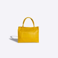 Large Tote Bag The large yellow Calista Tote Bag is oversized and designed to carry all of your work and travel essentials. Made of durable Saffiano Leather, this will be your go to work bag or travel tote to be carried for years to come. With a rigid construction, this tote bag is perfect for carrying large loads, yet will stand on its own four gold-toned feet no matter where you place it. The built in leather straps allow you to carry it as a shoulder bag, and you can convert it into a crossbo Luxury Yellow Rectangular Bags, Solid Color Rectangular Box Bag For Travel, Luxury Yellow Satchel Box Bag, Yellow Satchel With Top Carry Handle For On-the-go, Luxury Yellow Satchel With Large Capacity, Luxury Large Capacity Yellow Satchel, Luxury Large Capacity Yellow Bags, Travel Yellow Satchel, Luxury Yellow Tote Bag