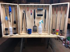 an open cabinet with tools hanging on the wall