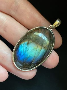 This oval Labradorite pendant is handmade and set in solid Sterling Silver. Each unique Labradorite stone has opalescent colors and shimmering patterns that are pure magic! Labradorite is in the Moonstone and Spectrolite mineral family and gets its name from the place it was originally discovered: Labrador, Canada. It is often referred to as a "Dream Stone" as it enhances the power of dreams and manifestation. Labradorite has the power to help you make your dreams come true! Shoot for the stars! Oval Labradorite Cabochon Jewelry, Oval Cabochon Labradorite Jewelry, Large Round Labradorite Gemstones, Iridescent Oval Gemstone Necklaces, Iridescent Oval Gemstone Necklace, Unique Oval Natural Gemstones, Labradorite Pendant With Natural Stones, Labradorite Cabochon Oval Pendant, Labradorite Cabochon Oval Pendant Jewelry