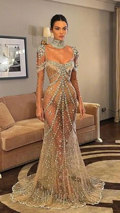 Luxury Floor-length Gown With Sheer Bodice, Glamorous Floor-length Evening Dress With Sheer Back, Elegant Floor-length Sheer Dress, Elegant Sheer Floor-length Dress, Glamorous Fitted Evening Dress With Illusion Neckline, Elegant Sheer Evening Dress For Prom, Glamorous Long Sleeve Gown With Sheer Bodice, Glamorous Gown With Illusion Neckline For Gala, Luxury Full Length Evening Dress For Wedding