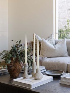 a coffee table with candles and books on it