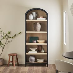 a shelf with vases and other items on it in the corner of a room