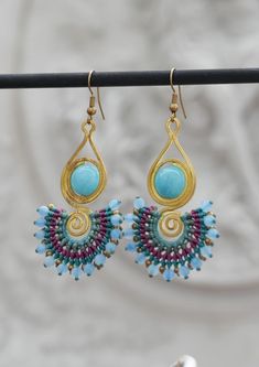 100% HANDMADE WITH LOVE IN THAILAND 💖 These stunning handmade earrings feature a delightful combination of the natural tone of color in shade of blue, yellow and purple all beautifully woven together with cotton wax thread and spiral brass. Not only are they incredibly comfortable for everyday wear, but they also make the perfect gift for friends and loved ones. Explore the beauty of handmade craftsmanship and elevate your style with these unique pieces. Shop now and spread the joy of Thailand Handmade Jewelry! 🌟 Length: 5 cm Width: 3 cm Weight: 7 grams/pair *If you are not sure about the size please feel free to contact me I would be happy to help 💖 Bohemian Wire Wrapped Earrings For Jewelry Making, Bohemian Chandelier Earrings For Pierced Ears, Handmade Bohemian Chandelier Dangle Earrings, Bohemian Adjustable Teardrop Earrings, Handmade Bohemian Beaded Earrings With Adjustable Fit, Bohemian Wire Wrapped Beaded Earrings As Gift, Bohemian Turquoise Beaded Earrings As Gift, Bohemian Turquoise Chandelier Earrings As A Gift, Bohemian Beaded Earrings Gift