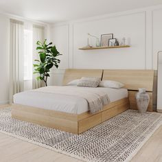 a large bed sitting on top of a wooden floor next to a potted plant