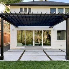 an outdoor patio with a pergolan and sliding glass doors