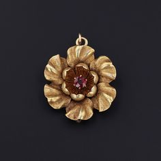 "\"If we could see the miracle of a single flower, our whole lives would change.\" -Buddha This antique pendant (circa 1910) doubles as a brooch and features a flower of 14k gold with a single red garnet accent at its center. The piece measures 1.2 inches from the top of the bail to bottom by 0.9 inches wide, and it is in great condition. We have many other fantastic offerings of period fine jewelry posted on our Etsy store, so please consider browsing our other items. We send all items in indiv Antique Pendant Brooch Hallmarked, Antique Pendant Brooches Hallmarked, Antique Hallmarked Pendant Brooches, Gold Pendant Brooch For Ceremonial Use, Engraved Yellow Gold Pendant Brooch, Victorian Gold Pendant Brooches, Gold Flower Heirloom Jewelry, Heirloom Gold Flower Jewelry, Gold Brooch With Large Pendant As Gift