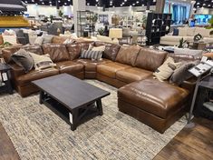 a living room filled with lots of couches and pillows on top of a rug