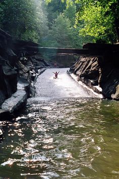 a person jumping into the water from a bridge