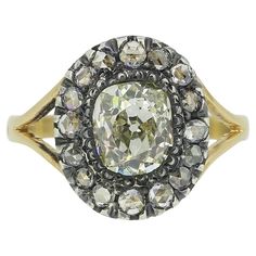 Here we have a beautifully assembled diamond cluster ring dating back to the Victorian period. A single oval shaped old mine cut diamond sits proud at the centre of the face in a silver collet setting. This chunky principle stone is then framed by a circulating array of tiny rose cut diamonds around the outer edge in a single line formation before the piece is finished with open split shoulders and an otherwise plain polished band. This piece started life as a stick pin but has been experty transformed into a more practical everyday ring by master antique jewellery re-designer and restorer, Gaetano Chiavetta. Condition: Used (Very Good) Weight: 2.7 grams Size: J (49) Band Width: 2mm Face Dimensions: 12mm Centre Diamond Weight: Approx. 1.16ct Diamond Details: Colour: L, Clarity: SI Rose Cut Oval Diamond White Cluster Ring With Single Cut Diamonds, Oval Cluster Ring With Single Cut Diamonds In White, Oval Cluster Ring With Single Cut Diamonds, Anniversary Oval Cluster Ring With Rose Cut Diamonds, Oval Cluster Ring With Rose Cut Diamonds For Anniversary, Antique Cushion Cut Single Diamond Rings, Antique Cushion Cut Ring With Single Cut Diamonds, Antique Cushion Cut Rings With Single Cut Diamonds, Oval Rose Cut Diamond Heirloom Ring