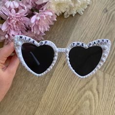 a pair of heart shaped sunglasses with the words wife of the party written on them