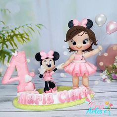 a birthday cake with a girl and mickey mouse figurine